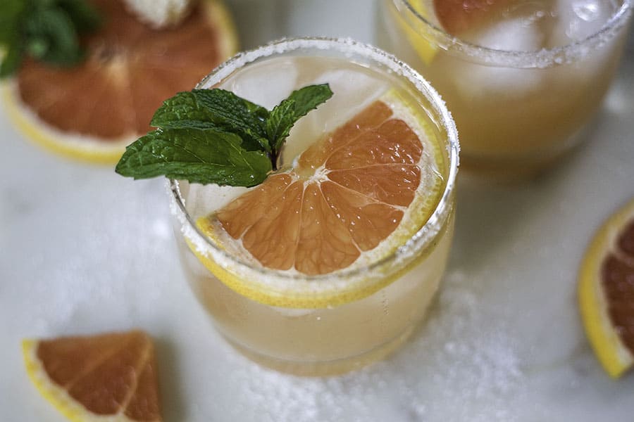 glass of salty dog grapefruit cocktail with mint leaves and grapefruit slice