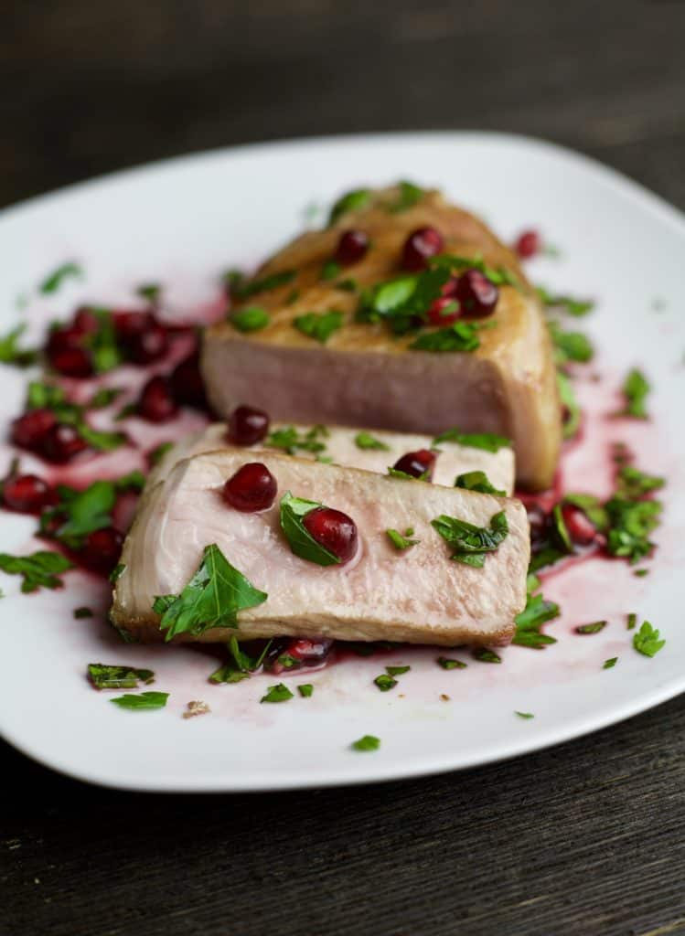 sliced grilled pork chops topped with pomegranate sauce