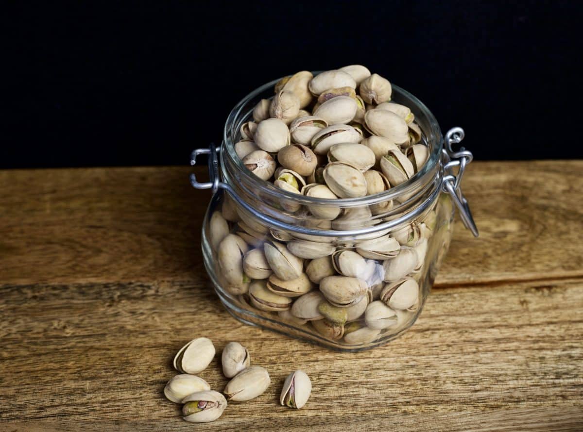 jar of pistachio nuts in their shells on a table