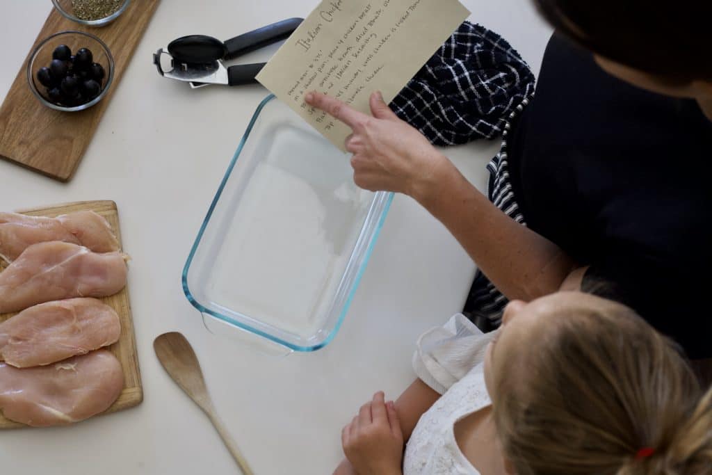 reading recipe card to make italian chicken