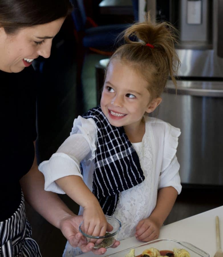 little girl smiling while cooking