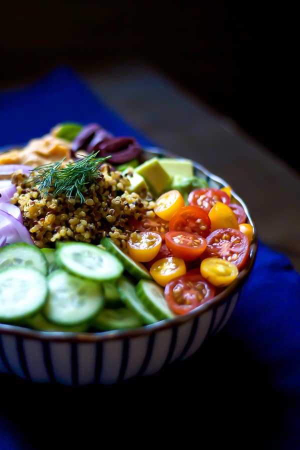 mediterranean plan protein power bowl - quinoa, hummus, olives, cucumber and tomato. a quick and easy vegetarian mediterranean lunch recipe