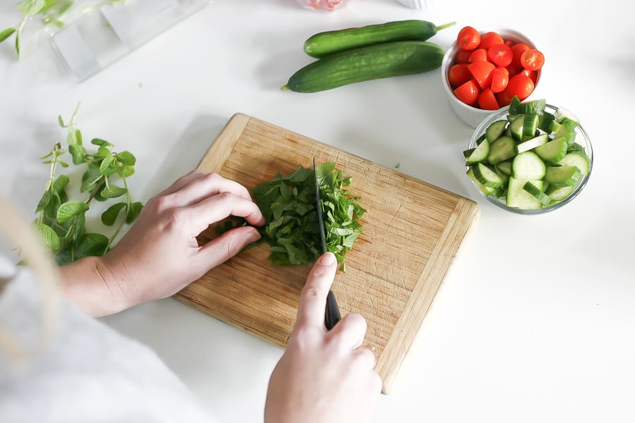 chopping fresh herbs for greek farro salad recipe