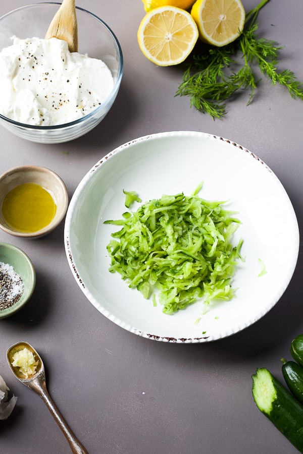 ingredients for homemade tzatziki sauce - cucumber, yogurt, lemon, dill, garlic