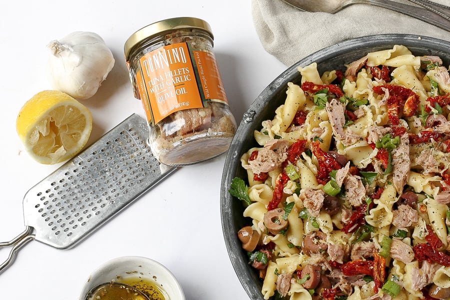 jarred tuna and bowl of mediterranean tuna pasta salad