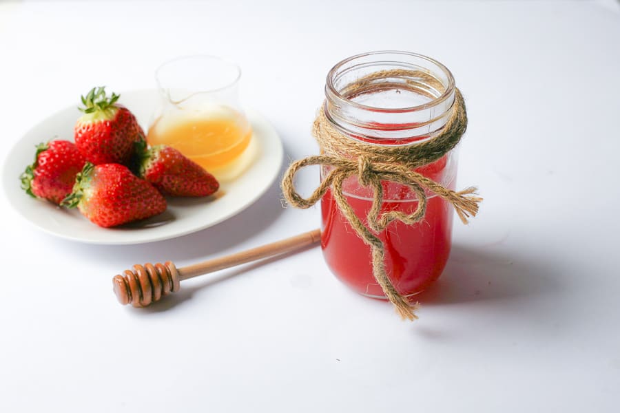 strawberry honey infusion with plate of berries and honey spoon