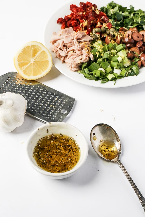 olive oil and ingredients for mediterranean tuna pasta salad recipe