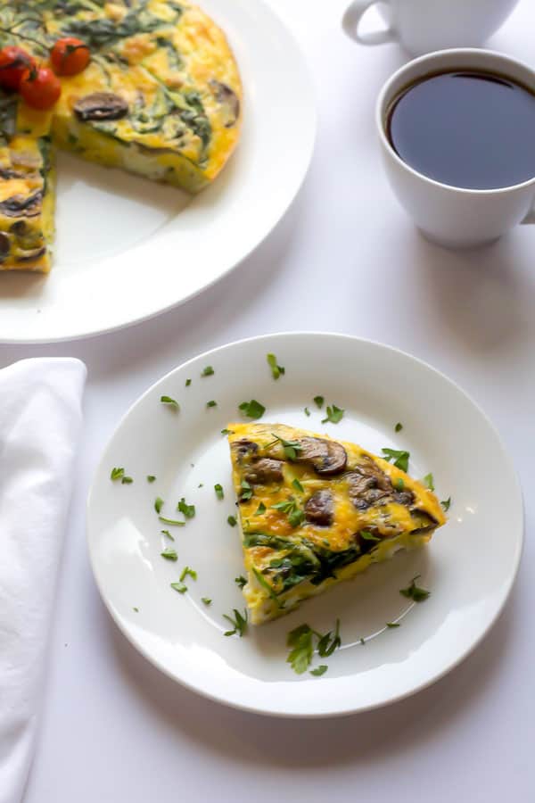 slice of spinach and mushroom frittata with coffee as part of mediterranean diet inspired recipe