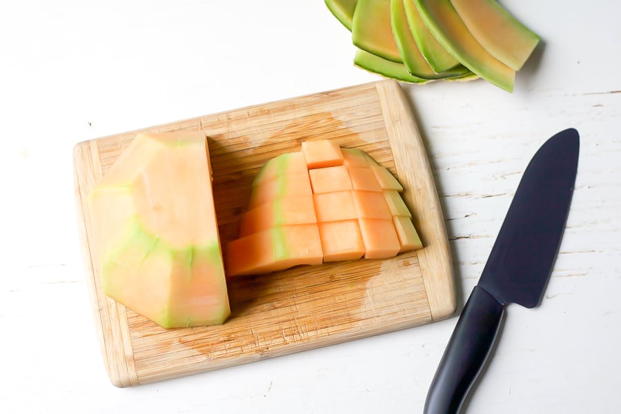 dicing cantaloupe on cutting board