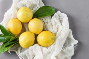 5 lemons on a cheesecloth with leaves for healthy affordable mediterranean diet hacks