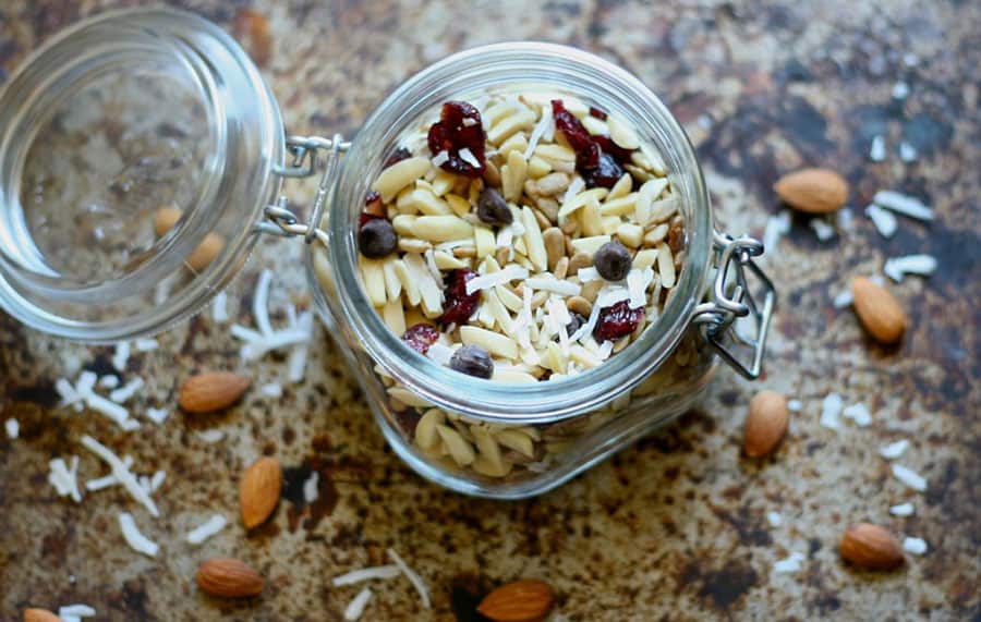 jar of healthy trail mix made at home with almonds coconut dried cranberries and chocolate chips