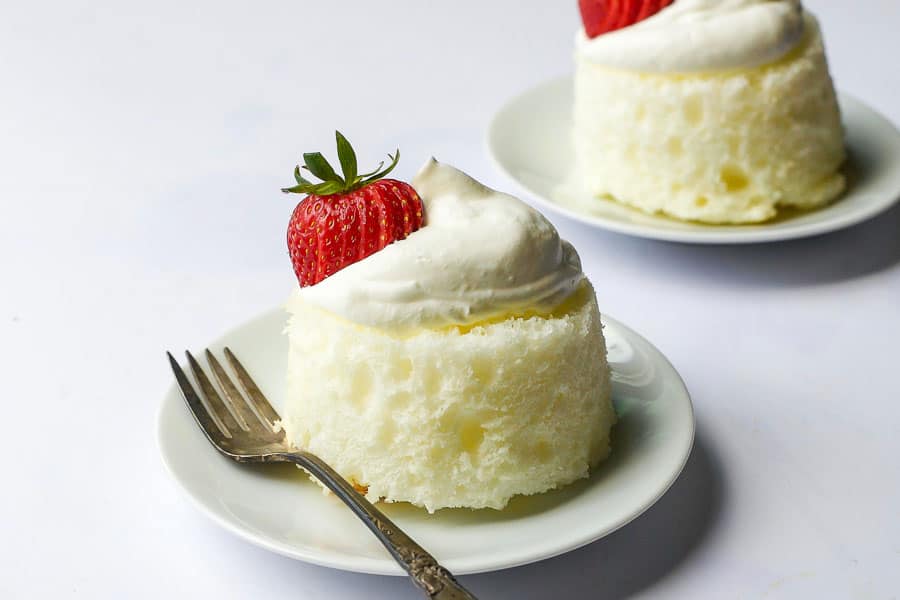 two mini angel food cakes with strawberries and almond whipped cream