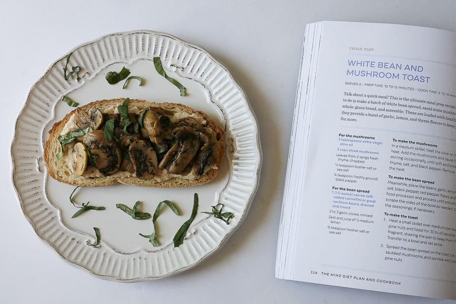 white bean and mushroom toast next to open cookbook page