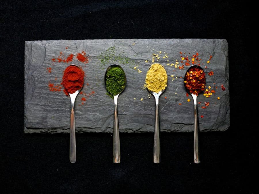 four spoons showing different colorful spices used in homemade spice blends for mediterranean diet hacks