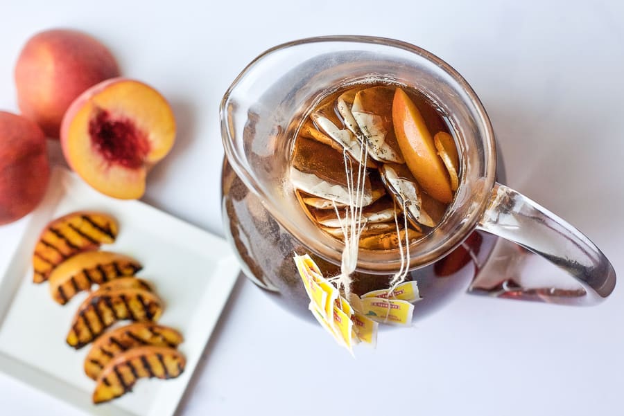 pitcher of brewing peach iced tea