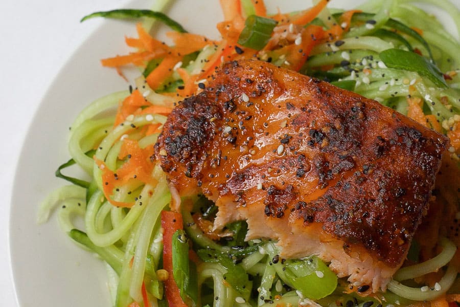 grilled cedar plank salmon on top of fresh vegetables