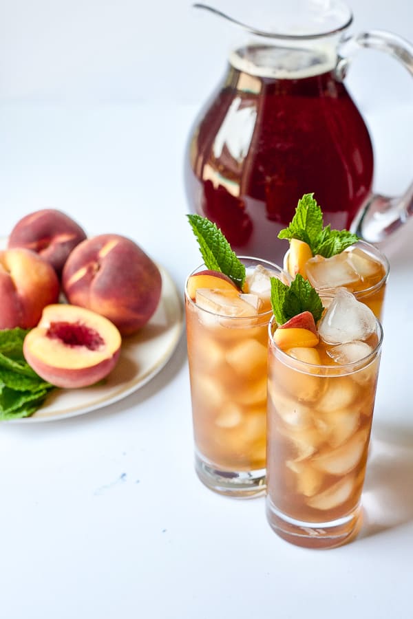 refreshing glasses and pitcher of grilled peach iced tea garnished with mint