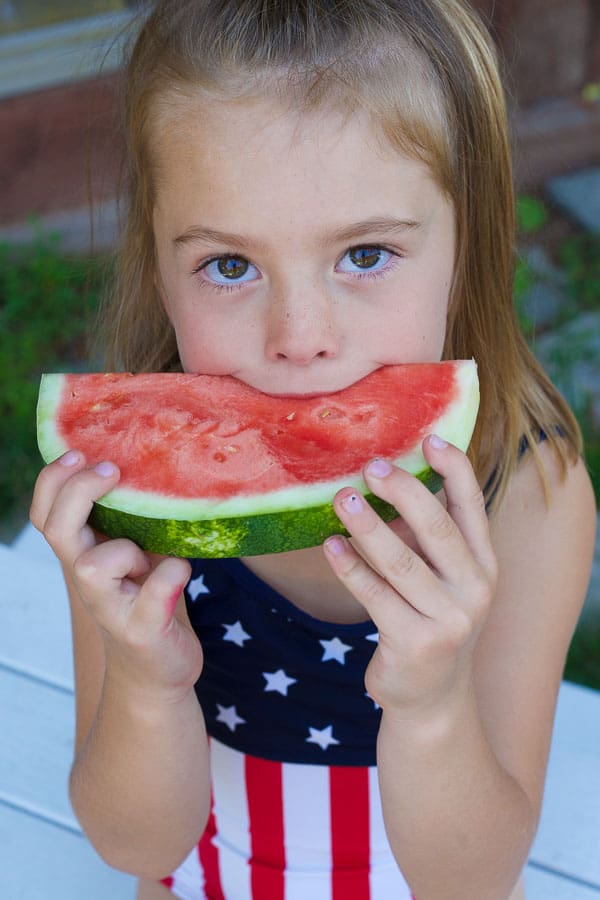 girl eating watermelon slice in summer