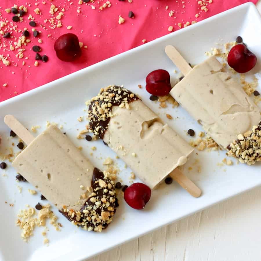 banana split popsicles with cherry garnish
