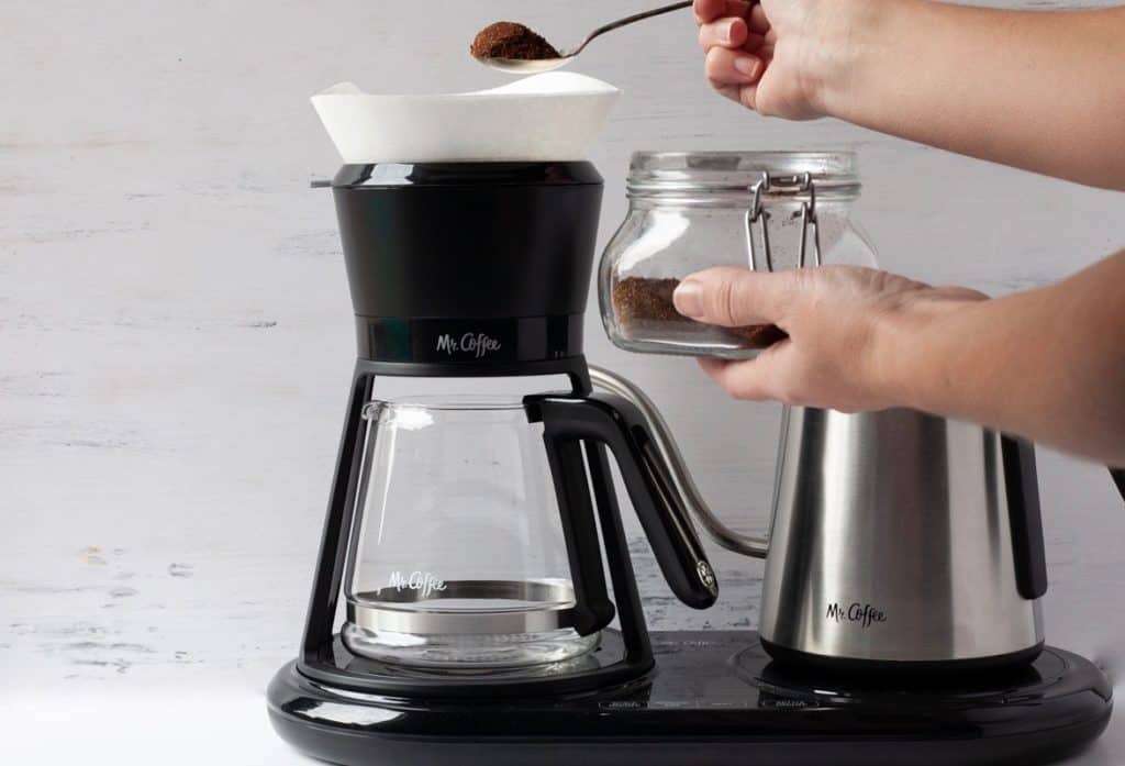 adding grounds to pour over coffee maker