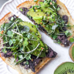 avocado toast with black beans and kiwi on side
